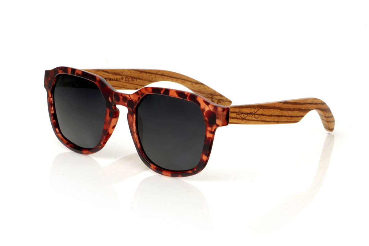 Wood eyewear of Zebrano MOON CAREY. MOON CAREY are everything you need to give an interesting twist to your routine. With their tortoiseshell frames in matte brown and black tones and hexagonal shape, these glasses capture the essence of everyday style. The special part comes with the Zebrano wood shafts, whose unique grain ensures that no two pairs are the same. Comfortable, with total protection and perfect for any adventure under the sun. They are a basic with an extra touch. Give your look that something special. Front measurement: 148x50mm. Caliber: 53. for Wholesale & Retail | Root Sunglasses® 